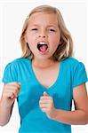 Portrait of a young girl screaming against a white background