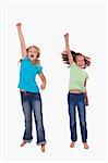 Portrait of girls jumping with their fists up against a white background