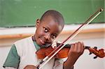 Schoolboy playing the violin in a classroom