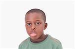 Boy sticking out his tongue against a white background