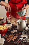 Photo of a female mixing ingredients in a large glass bowl. Could be muffins, cookies, bread, etc.