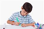 Young boy drawing against a white background