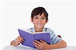 Happy boy reading a book against a white background