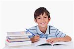Boy doing his homework against a white background