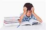 Focused boy learning his lessons against a white background