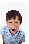 Portrait of a boy screaming at the viewer against a white background