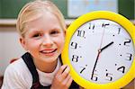 Schoolgirl showing a clock in a classroom