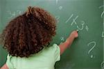 Schoolgirl pointing at an addition on a blackboard