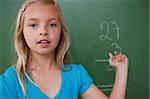 Little schoolgirl showing her result on a blackboard