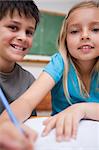 Portrait of two children writing in a classroom