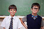 Schoolboys posing in front of a chalkboard in a classroom