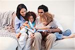 Young family on the sofa looking at the photo album together