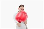 Young businesswoman boxing against a white background