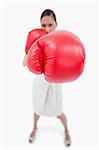 Portrait of a boxing businesswoman against a white background