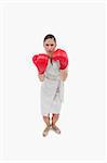 Portrait of a serious businesswoman with boxing gloves against a white background