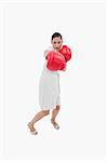 Portrait of a businesswoman punching someone against a white background