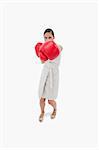 Portrait of a serious businesswoman punching someone against a white background