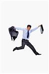 Cheerful businessman jumping while holding his jacket and a briefcase against a white background