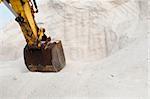 Excavator digging pile white salt