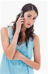 Portrait of a tired woman making a phone call against a white background