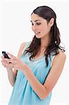 Portrait of a woman reading a text message against a white background