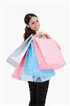 Portrait of a happy woman posing with shopping bags against a white background