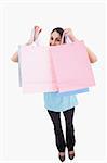 Portrait of a joyful woman showing shopping bags against a white background