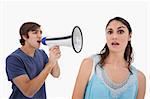 Man yelling at her girlfriend through a megaphone against a white background