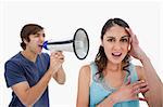 Man shouting at her girlfriend through a megaphone against a white background