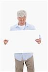 Portrait of a mature man looking at a blank panel against a white background