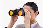 Brunette businesswoman looking through binoculars against a white background