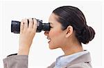 Side view of a businesswoman looking through binoculars against a white background