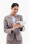 Portrait of a smiling businesswoman using a tablet computer against a white background