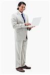 Portrait of a smiling businessman using a notebook against a white background