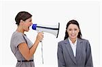 Businesswoman using megaphone to yell at colleague against a white background
