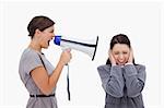 Businesswoman yelling at colleague with megaphone against a white background