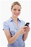 Smiling woman holding her cellphone against a white background