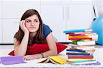 Daydreaming by the school books - pensive teenager girl at home