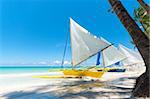 traditional paraw sailing boats on white beach on boracay island, Philippines