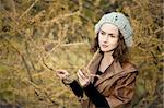 young girl in autumn forest standing near the tree