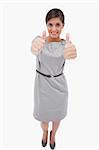 Smiling woman giving thumbs up against a white background