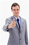 Thumb up given by businessman against a white background