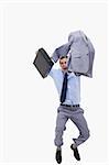 Happy businessman with suitcase jumping against a white background