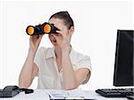 Young businesswoman looking through binoculars against a white background