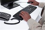 Close up of masculine hands using a computer against a white background