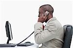 Side view of an angry businessman making a phone call against a white background