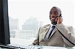 Smiling businessman on the phone in his office