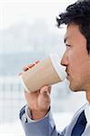 Portrait of an office worker drinking a takeaway coffee in his office