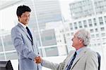 Employee shaking the hand of his manager in an office