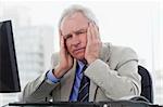 Tired senior manager working with a monitor in his office